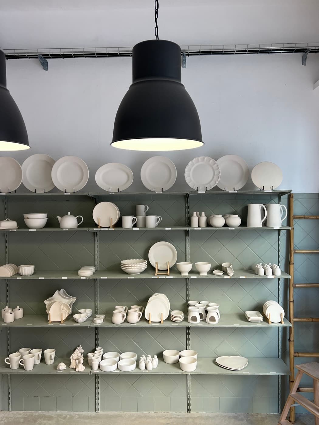 Estantería con piezas de cerámica sin pintar en CeramiLab